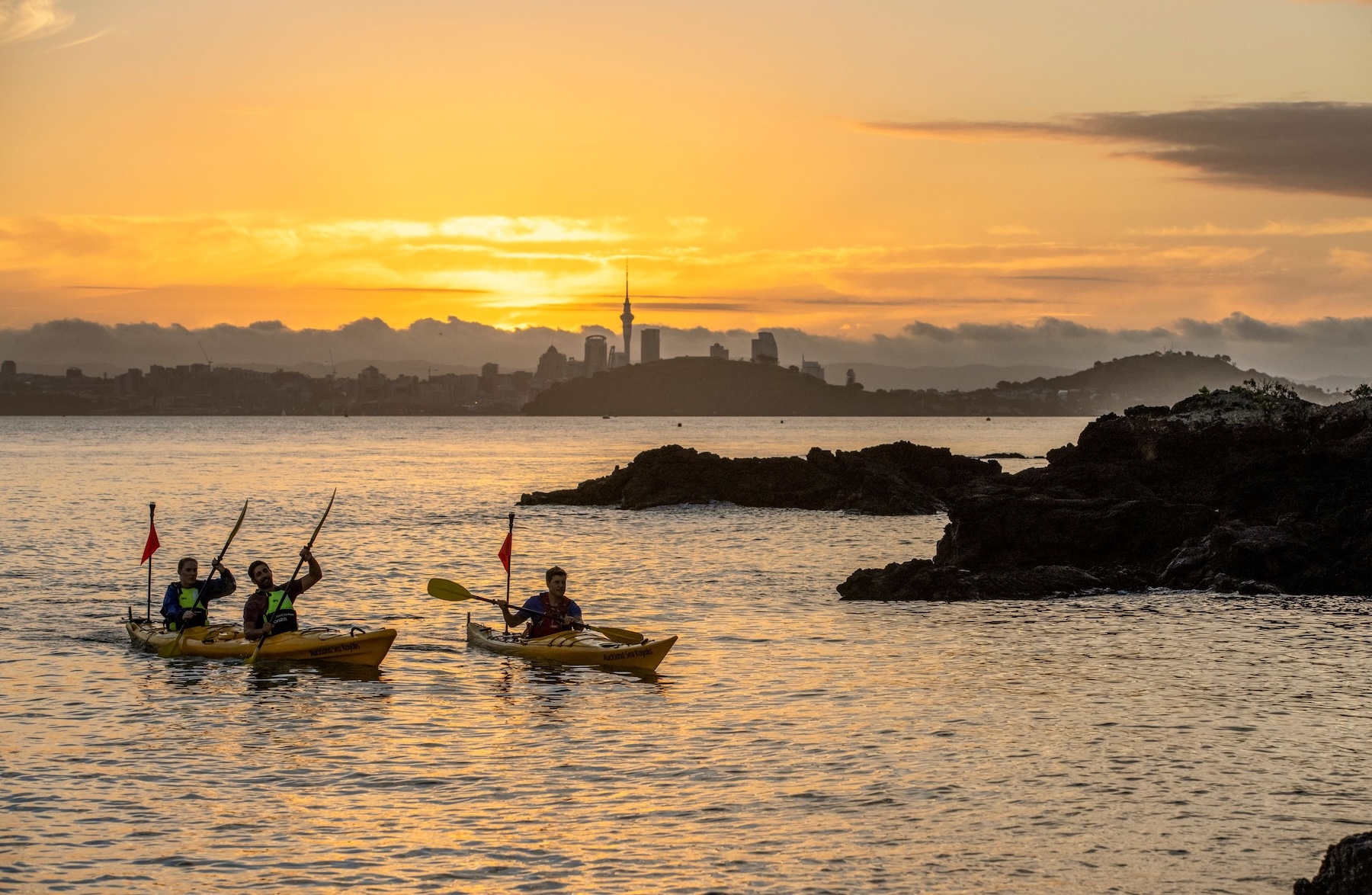 Kayaks navegando al atardecer en Nueva Zelanda