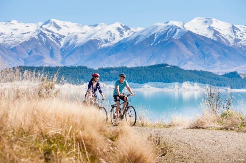 Inmigración en la Skilled Migrant Visa de Nueva Zelanda. Pareja montando en bicicleta por la montaña en Nueva Zelanda