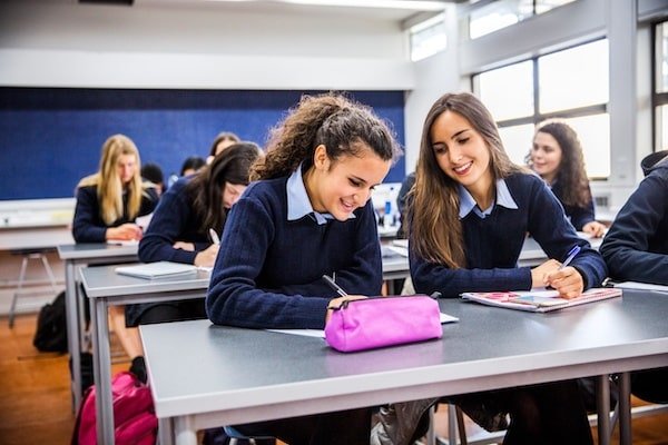 niveles-adaptados-estudiantes-colegio-nueva-zelanda-auckland Dos estudiantes realizando tareas en un aula en un colegio en Nueva Zelanda.